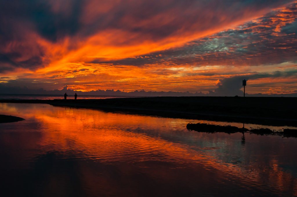Tramonto rosso riflesso su acqua